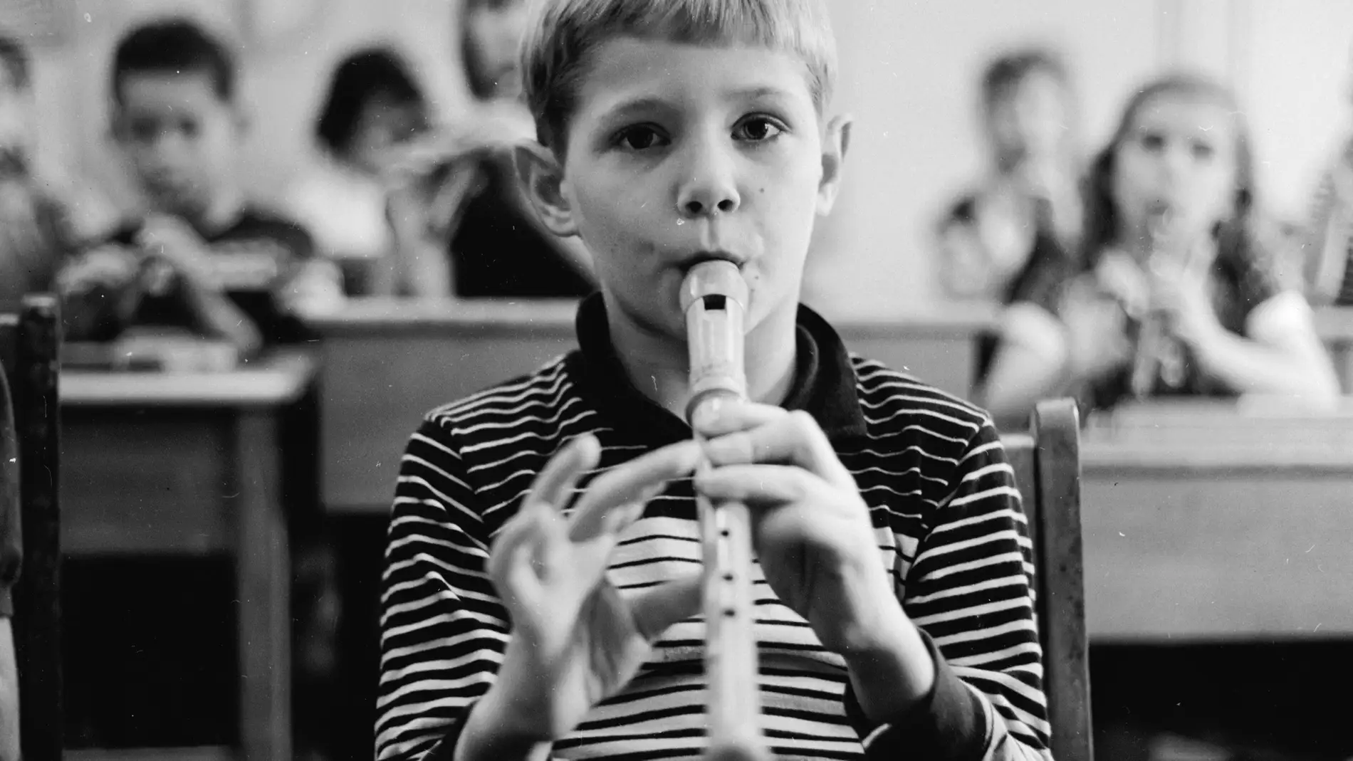 Un niño toca la flauta en clase de música