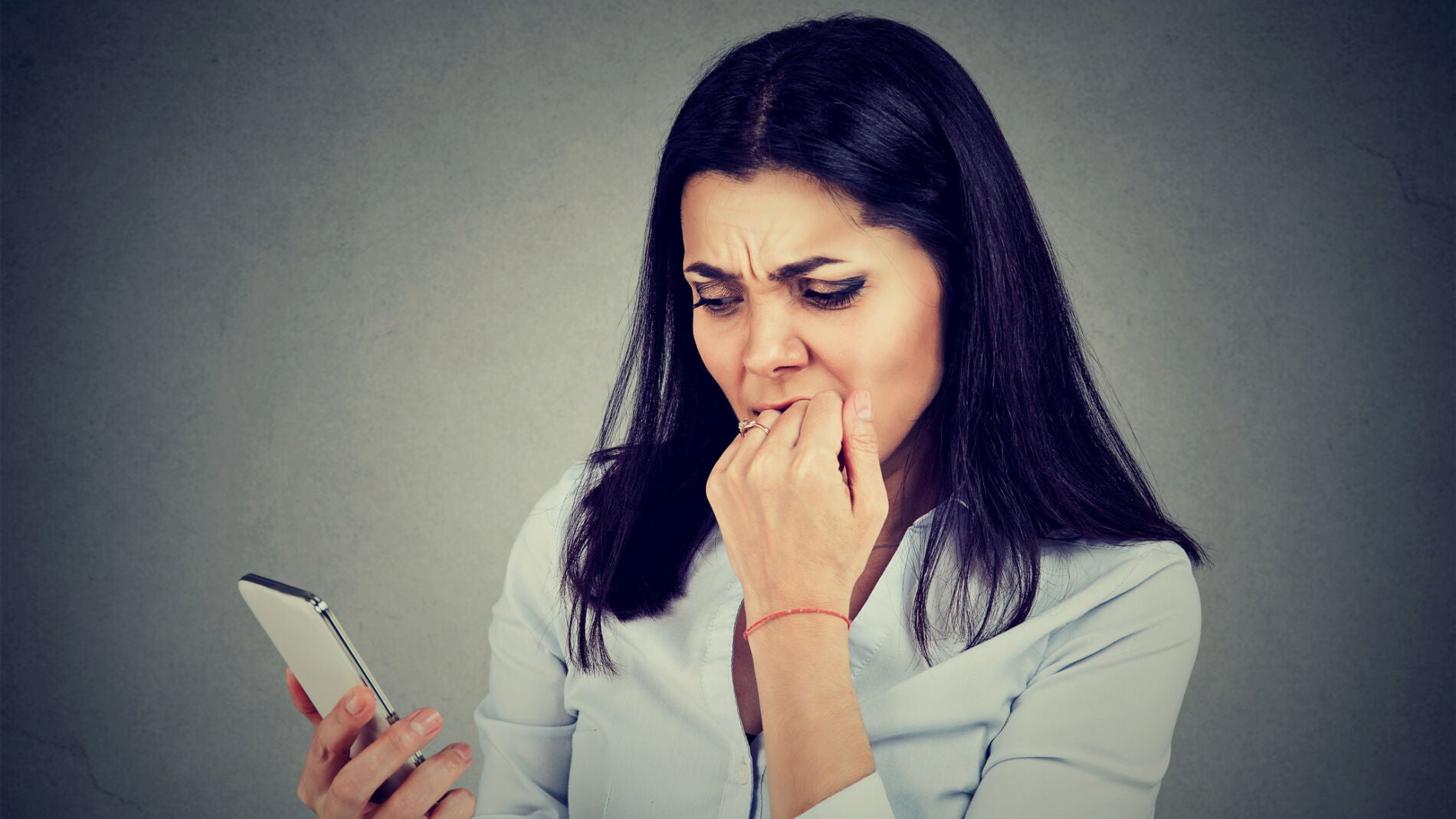 Mujer inquieta al revisar el m&oacute;vil