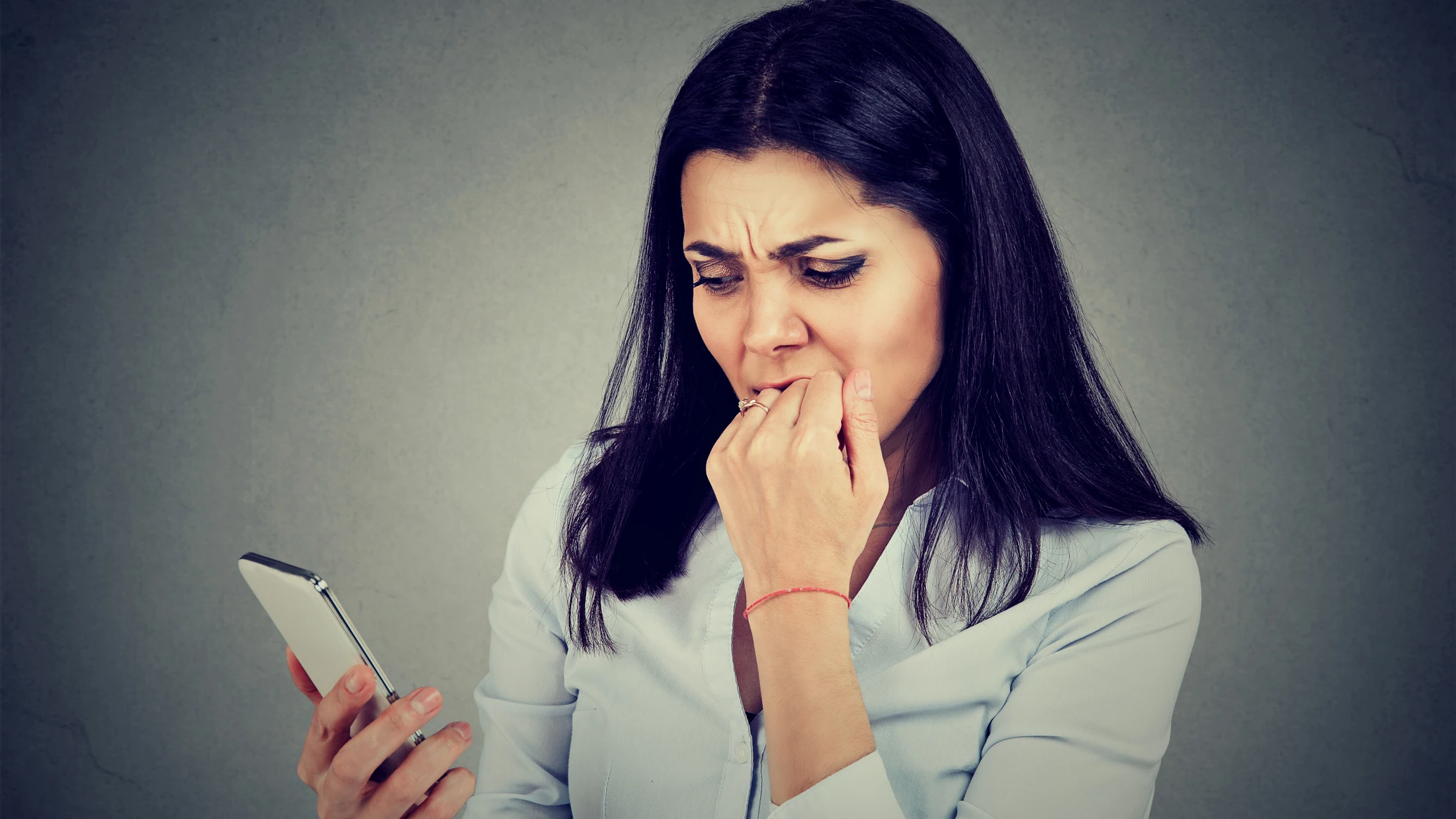 Mujer inquieta al revisar el móvil