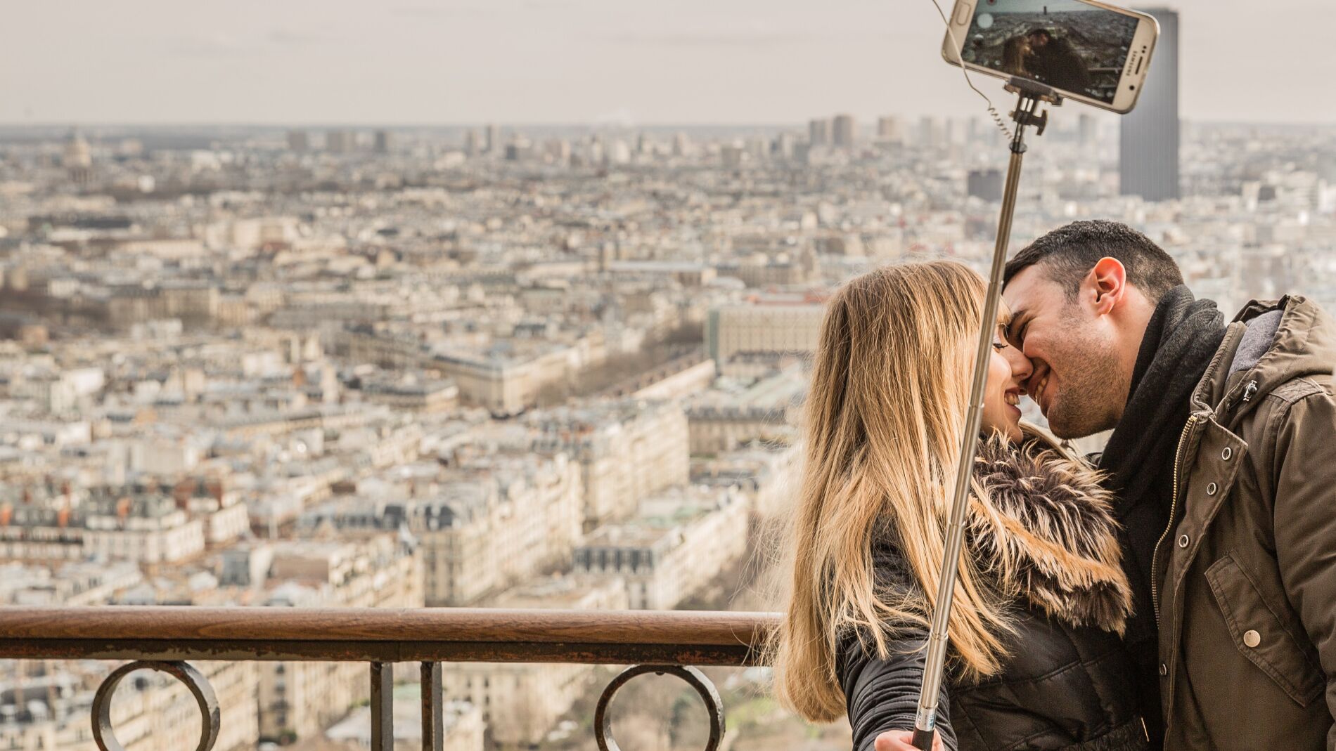 Pareja bes&aacute;ndose mientras se hace un selfie