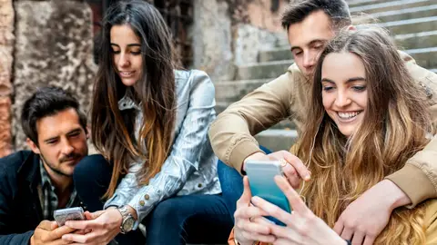 Grupo de chicos y chicas mirando el móvil Grupo de chicos y chicas mirando el móvil