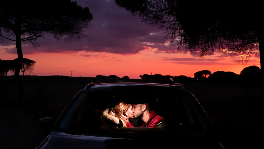 Pareja besándose en un coche