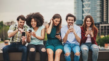Grupo de amigos analizando sus móviles