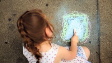 Niña dibujando en el suelo Niña dibujando en el suelo