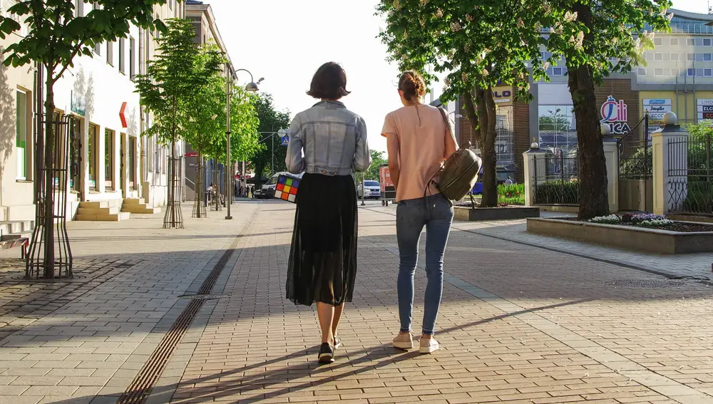 Dos chicas caminando solas por la calle de día