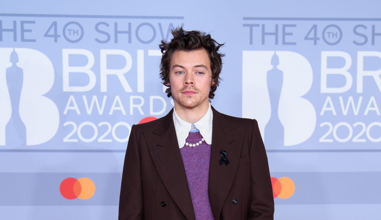 Harry Styles con un traje, jersey y collar de perlas