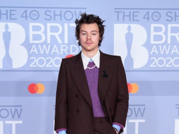 Harry Styles con un traje, jersey y collar de perlas