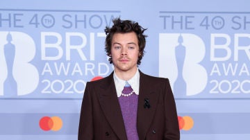 Harry Styles con un traje, jersey y collar de perlas