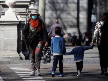 Un par de niños cruzan una calle en Madrid