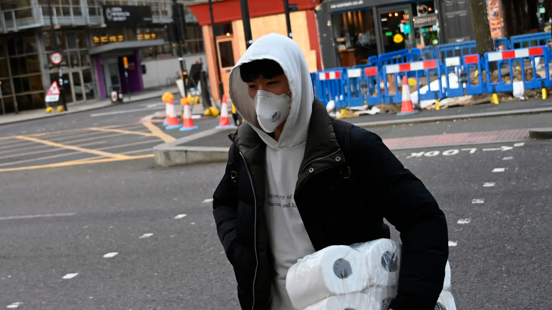 Un ciudadano británico, con rollos de papel higiénico en el brazo izquierdo