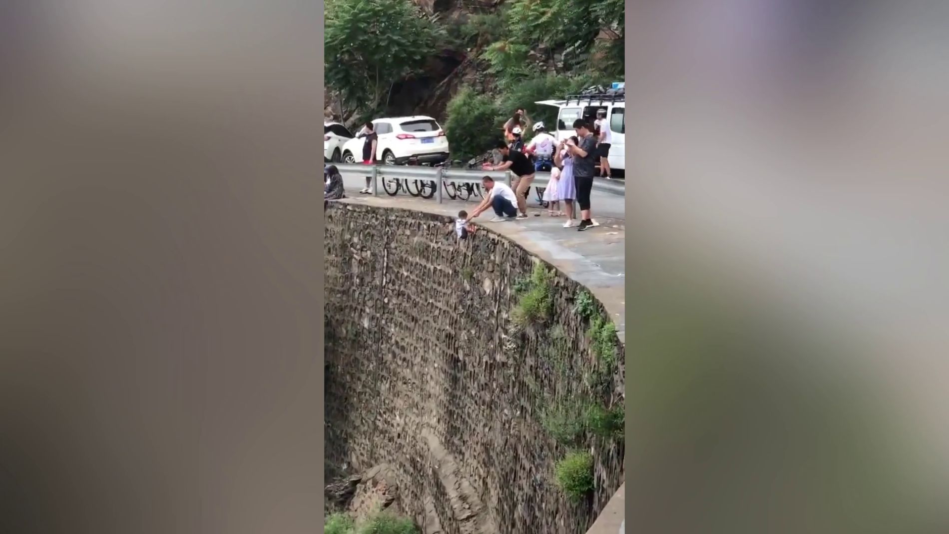 Cuelga a su hijo de un acantilado