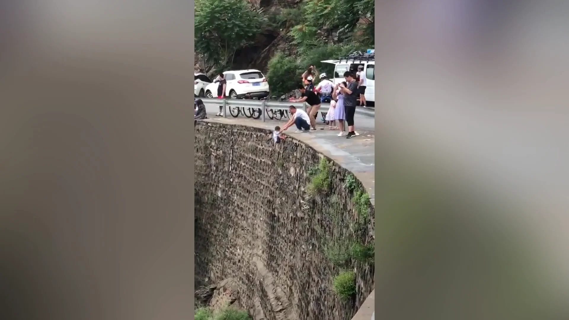 Cuelga a su hijo de un acantilado
