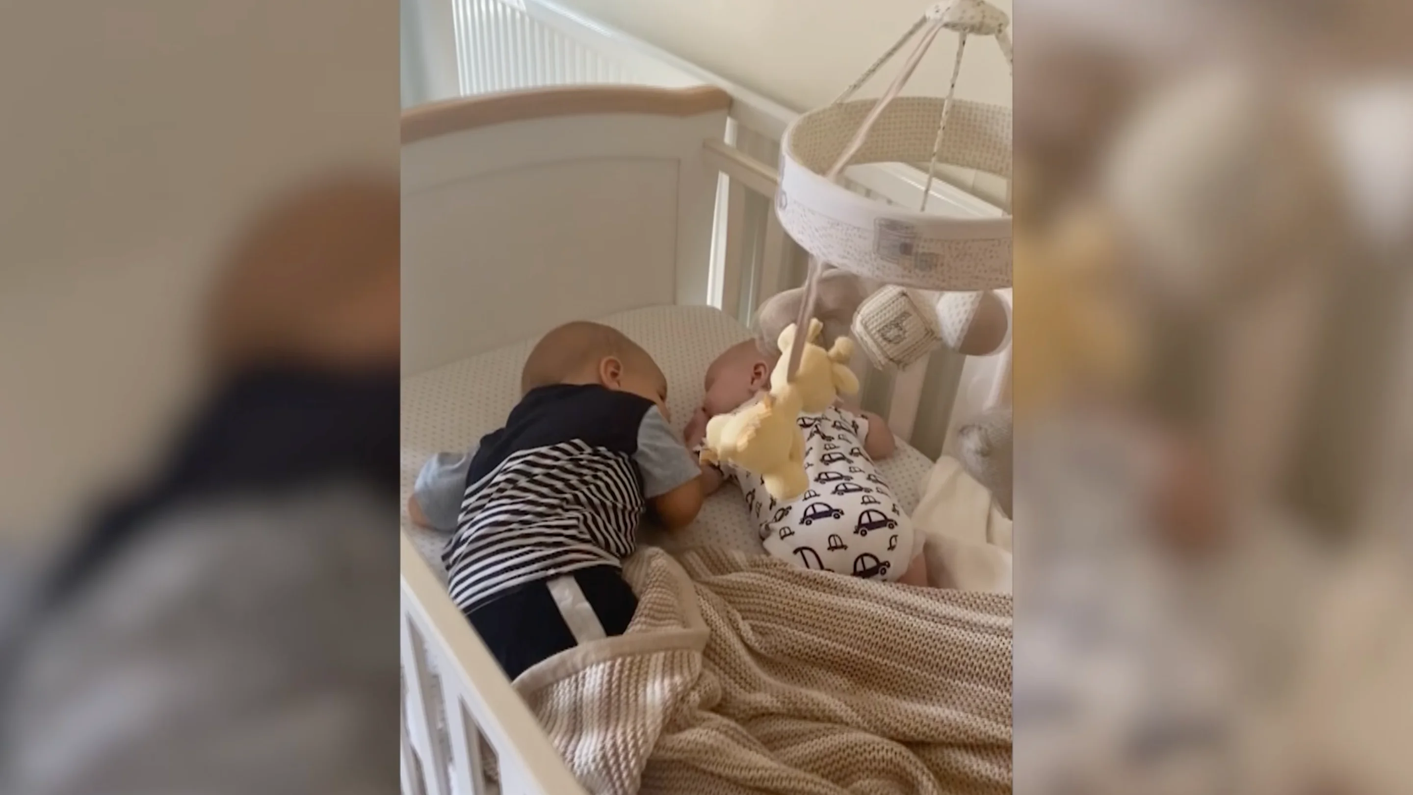 el bebé arropa a su hermano en la cuna el bebé arropa a su hermano en la cuna