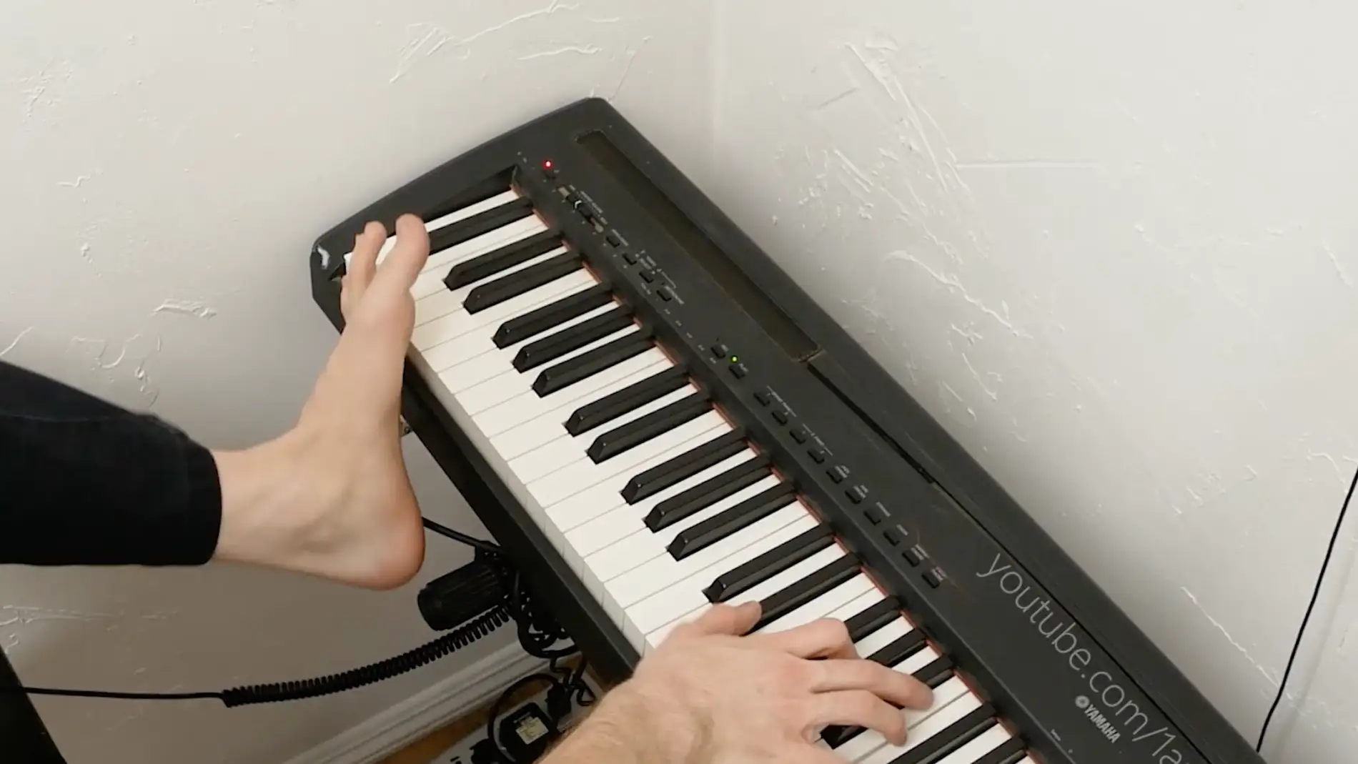 Un talentoso hombre juega a videojuegos y toca el piano con un solo brazo y un pie