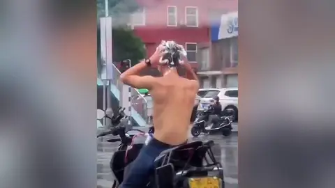 Un hombre aprovecha la lluvia para lavarse el pelo en un semáforo y acaba multado Un hombre aprovecha la lluvia para lavarse el pelo en un semáforo y acaba multado
