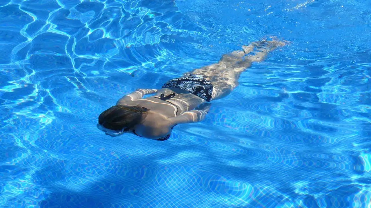 Una mujer nadando en la piscina.
