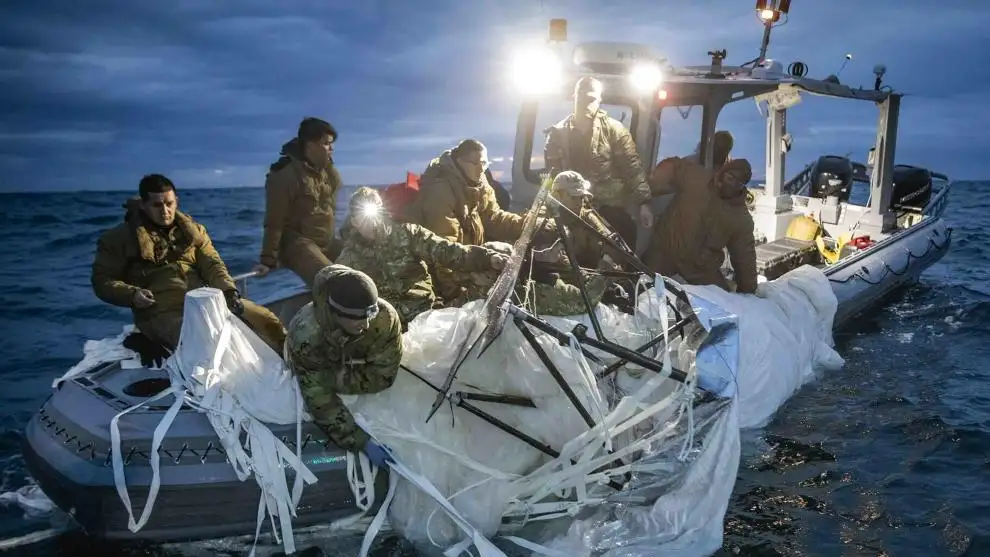 Soldados de la Fuerza Marítima a bordo de una lancha en el momento en el que recuperan una lona blanca