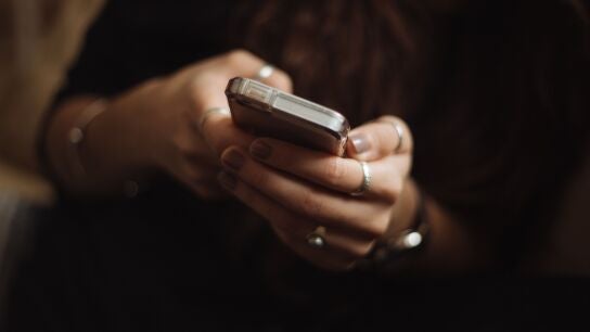 Una persona usando su tel&eacute;fono m&oacute;vil