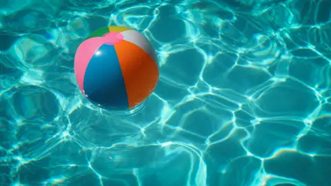 Una piscina con una pelota inflable Una piscina con una pelota inflable