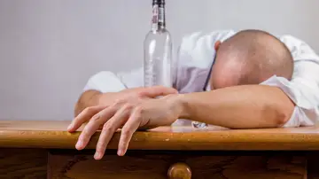 Fotografía de un hombre que se ha quedado dormido tras beber alcohol.