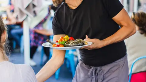 Tuit reseña negativa y "simpa" Camarero sirviendo comida