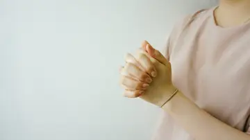 Mujer con las manos juntas rezando