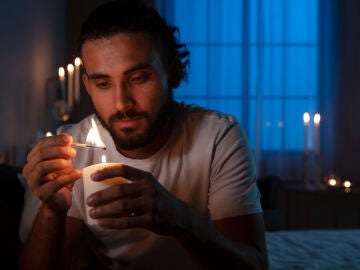 Imagen de un hombre encendiendo una vela