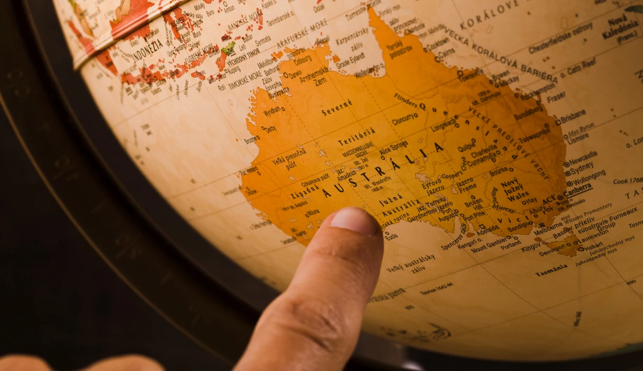 Imagen de un dedo señalando Australia en el mapa