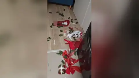 Un perro posa con expresión de inocencia tras desatar este caos navideño Un perro posa con expresión de inocencia tras desatar este caos navideño