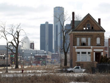 Casa abandonada con el edificio de General Motors de fondo, en Detroit, Michigan