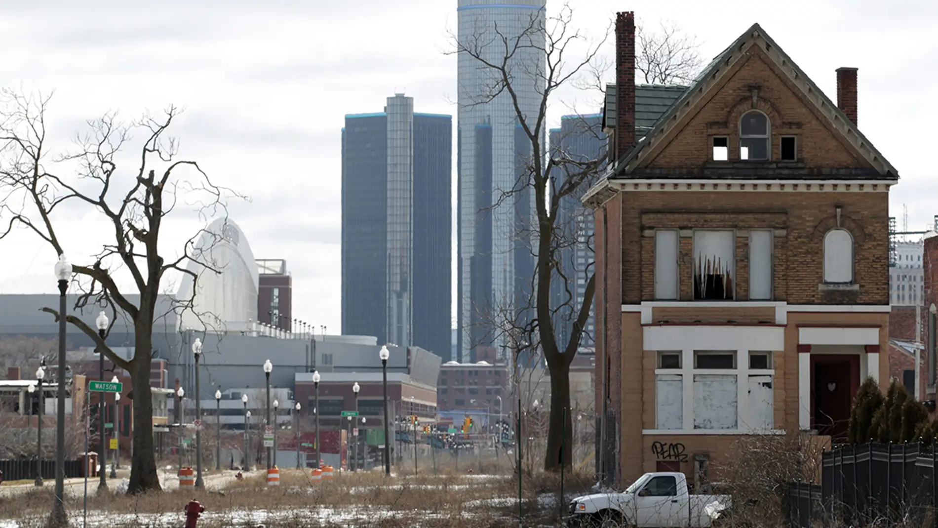 Casa abandonada con el edificio de General Motors de fondo, en Detroit, Michigan