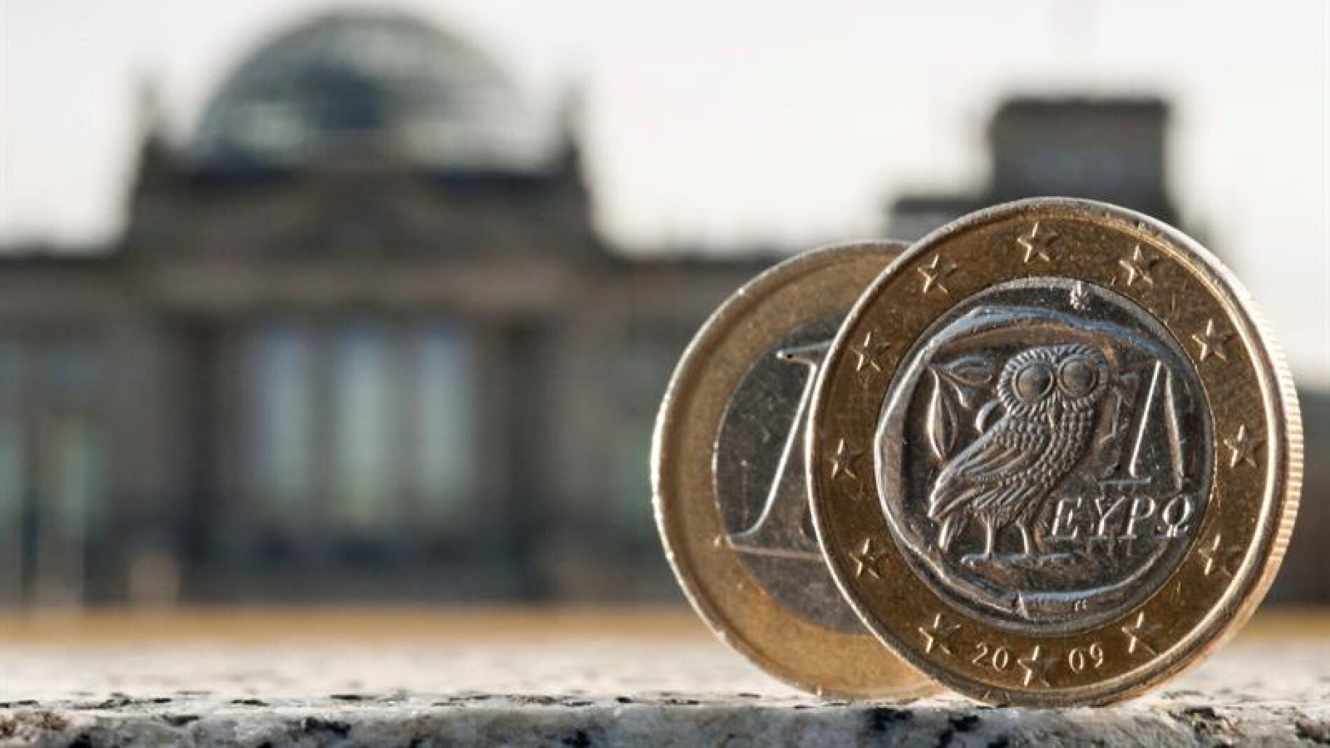 Dos monedas de euro, una de ellas acu&ntilde;ada en Grecia, fotografiadas delante del Bundestag en Berl&iacute;n (Alemania)