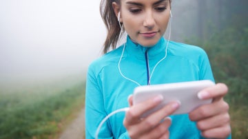 Una runner consulta su aplicación móvil