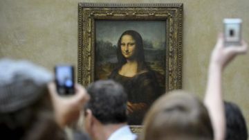 Turistas fotografiando 'La Gioconda' o 'Mona Lisa' en el Museo del Louvre