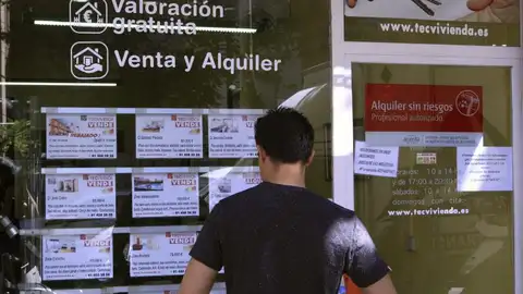 Imagen de archivo de un joven ojeando anuncios de pisos Venta y alquiler