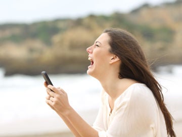 Joven enfadada que mira su teléfono móvil