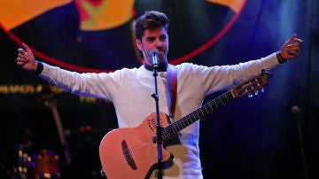 Roi Méndez toca la guitarra durante un concierto