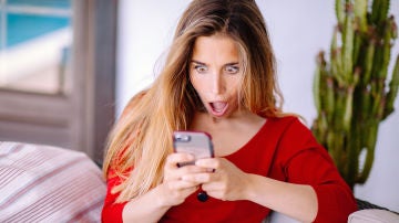 Chica mira sorprendida su móvil