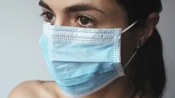 Una mujer se protege del coronavirus con una mascarilla 
