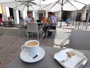  Varias personas disfrutan de la terraza de un bar.