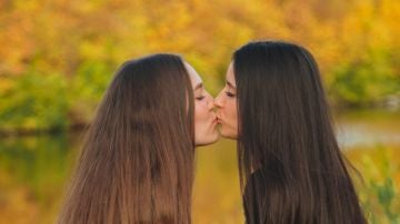 Dos chicas dándose un piquito