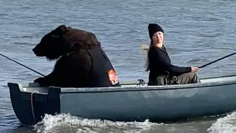 Un oso rescatado pescando con su dueña Un oso rescatado pescando con su dueña