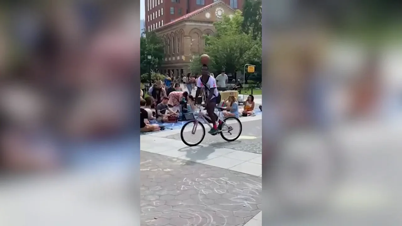 Un chico sujeta una pelota de baloncesto en la cabeza&hellip; &iexcl;mientras monta en bici sin manos!
