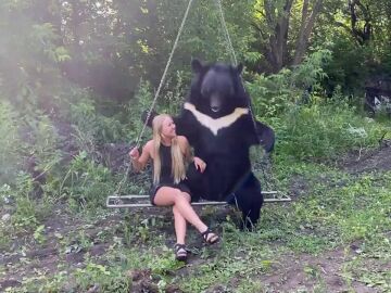 Una mujer se columpia con un oso gigante en Siberia