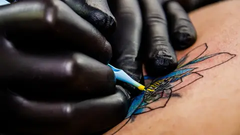 Tatuador haciendo una tatuaje Tatuador haciendo una tatuaje