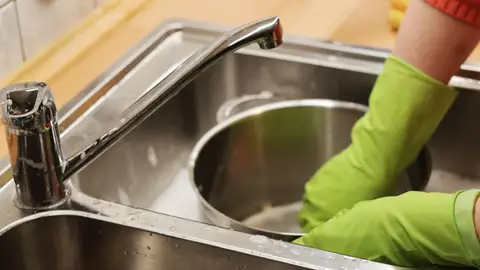 Persona limpiando platos (archivo) Persona limpiando platos (archivo)