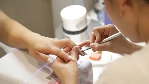 Una persona haciéndose las uñas Una persona haciéndose las uñas