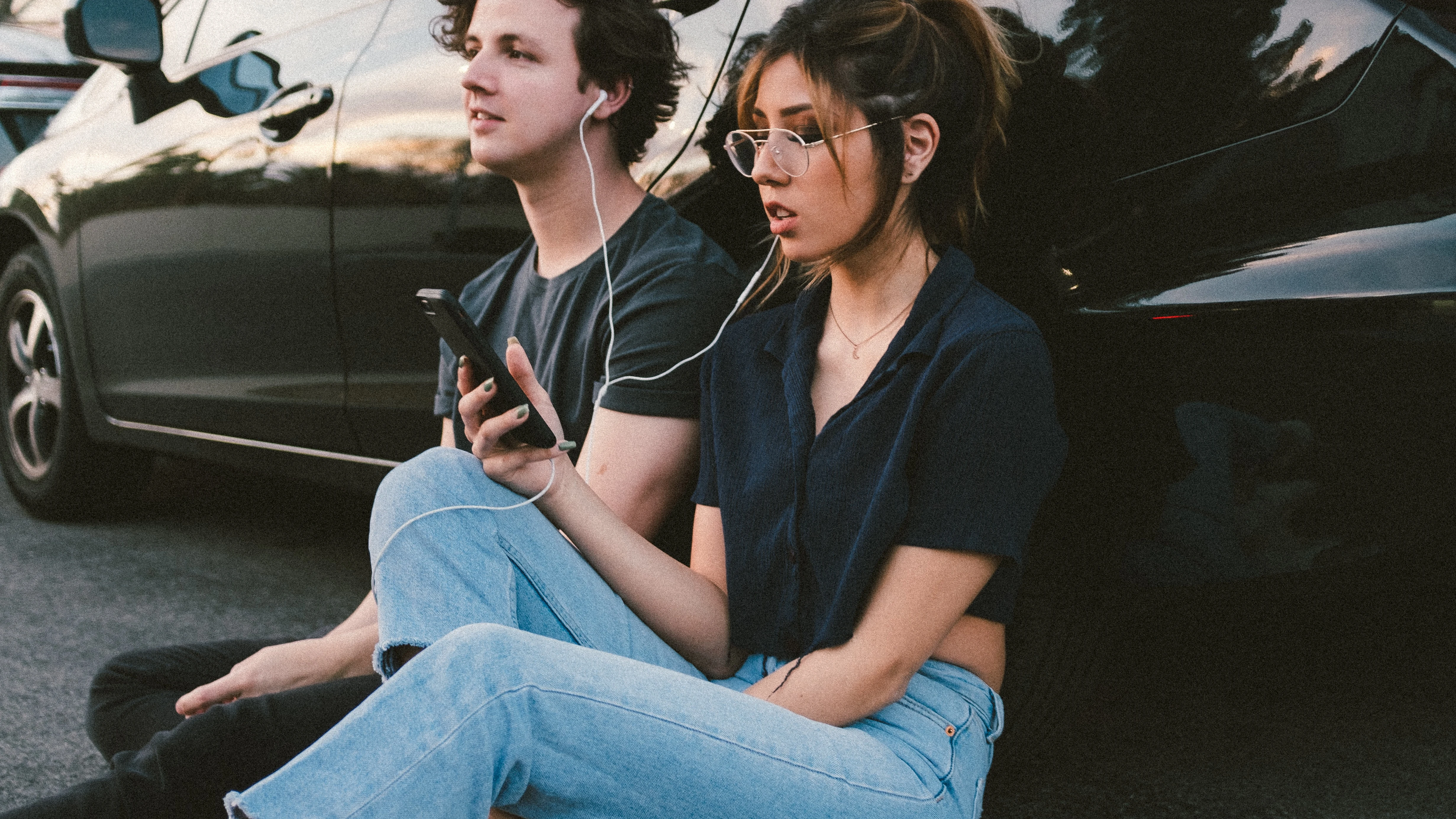 Pareja escuchando m&uacute;sica fuera del coche