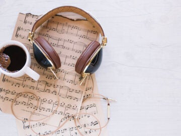 Imagen de unos auriculares y un caf&eacute; sobre una partitura