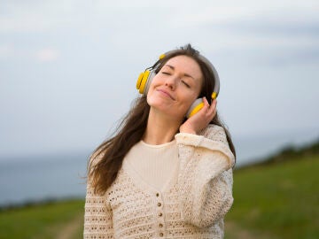 Imagen de una mujer relajada escuchando m&uacute;sica